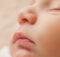 This is a close-up of a sleeping baby’s face. They look calm and peaceful.